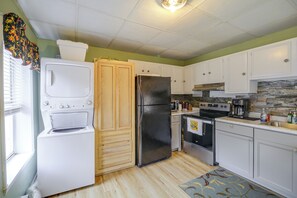 A kitchen with white cabinets, a black refrigerator, a stove, and a microwave. - Historic Welch Retreat! Ride, Hike & Explore (Welch)