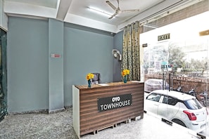 A reception desk with a sign reading 'OYO TOWNHOUSE' and a 'No Smoking' sign on the wall. - Signature Hotel Noida-62 (Noida)