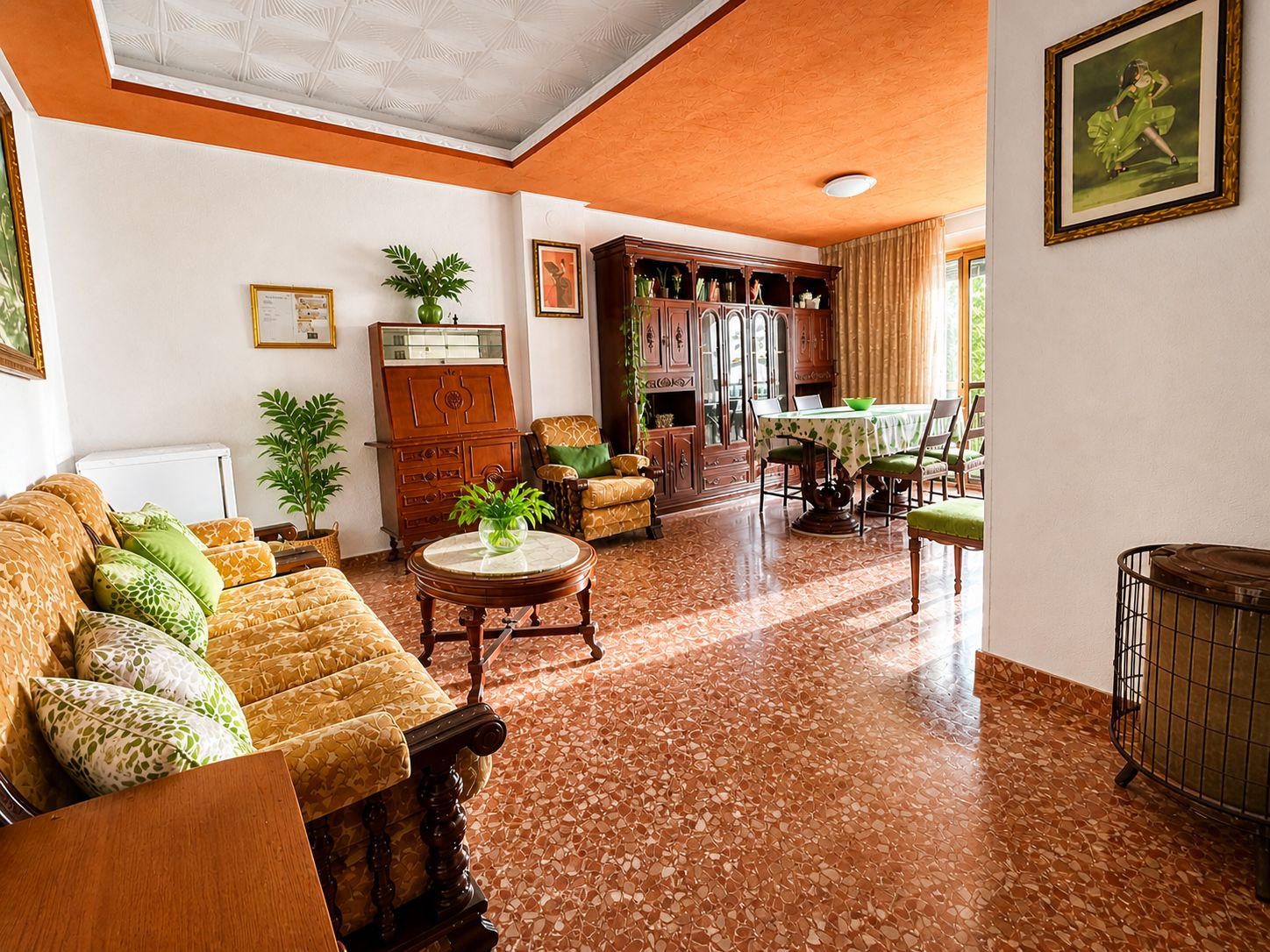 Un soggiorno spazioso con soffitto alto, una zona pranzo con tavolo e sedie, e un angolo cottura con mobili e fornelli.