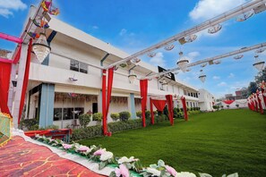 Un edifici amb façana blanca, cortines vermelles i decoracions penjants.