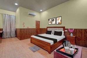 A hotel room with a wooden bed, a bedside table with a kettle, a tray with cups, and a window with curtains. - Hotel O Takrohi Hospital Road (Lucknow)