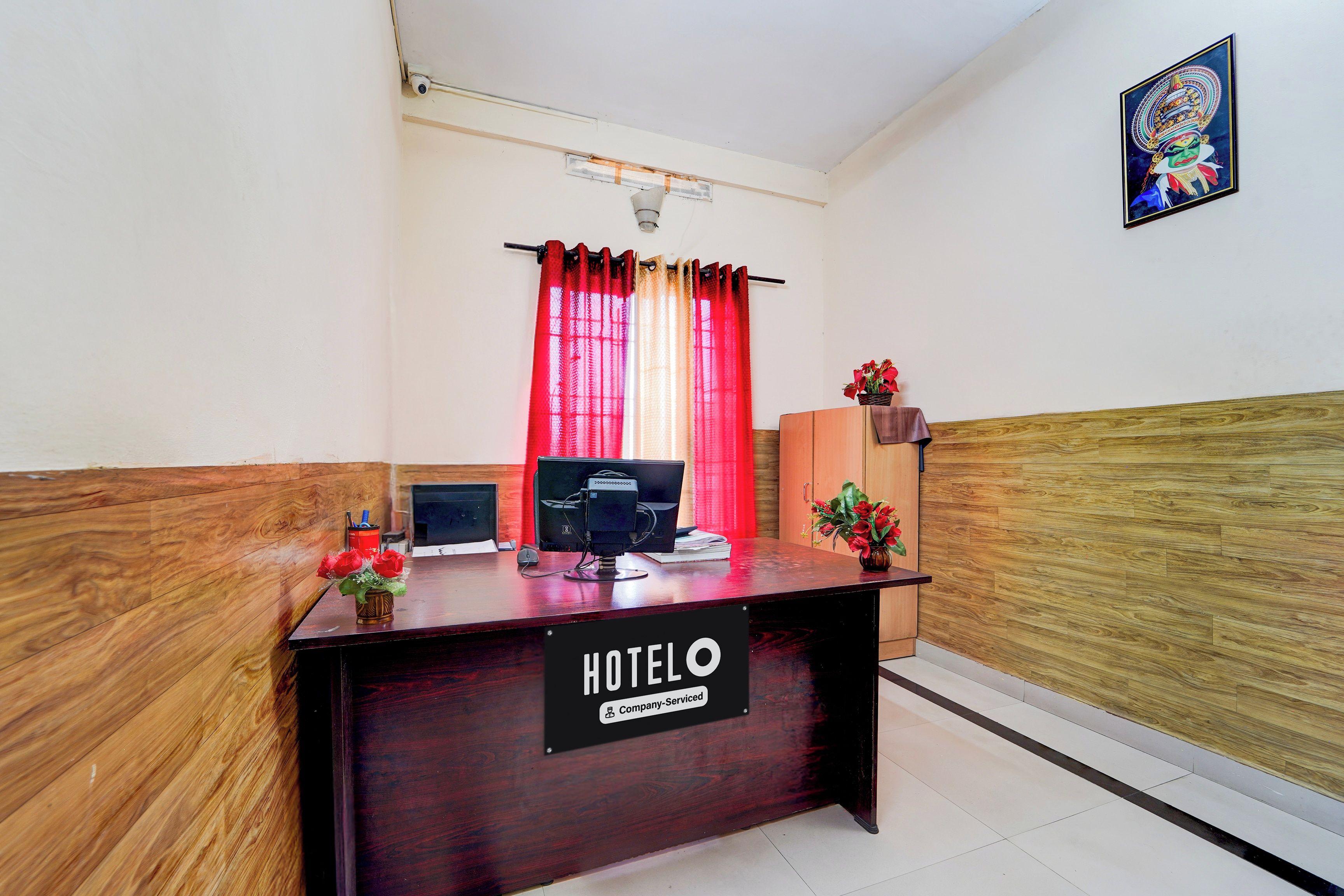 A hotel reception desk with a sign indicating it is company-serviced.
