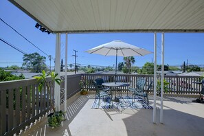 A covered patio with a table and chairs, a white umbrella, and a railing. - Chic Apt < 5 Mi to SDSU! Private Patio & Views (La Mesa)