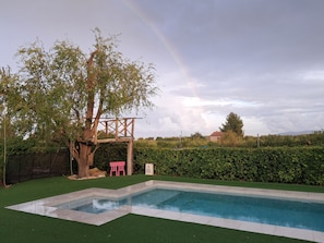 A swimming pool with a wooden deck and a tree. - New Listing (Bullas)