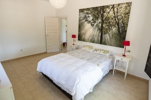 A bedroom with a bed, two bedside tables, a door, and a large forest-themed painting on the wall. - New Listing (Bullas)