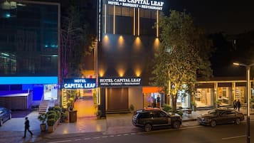 Un hôtel dont l’enseigne bien visible indique : « HÔTEL CAPITAL LEAF, SALLE DE BANQUET, RESTAURANT ».