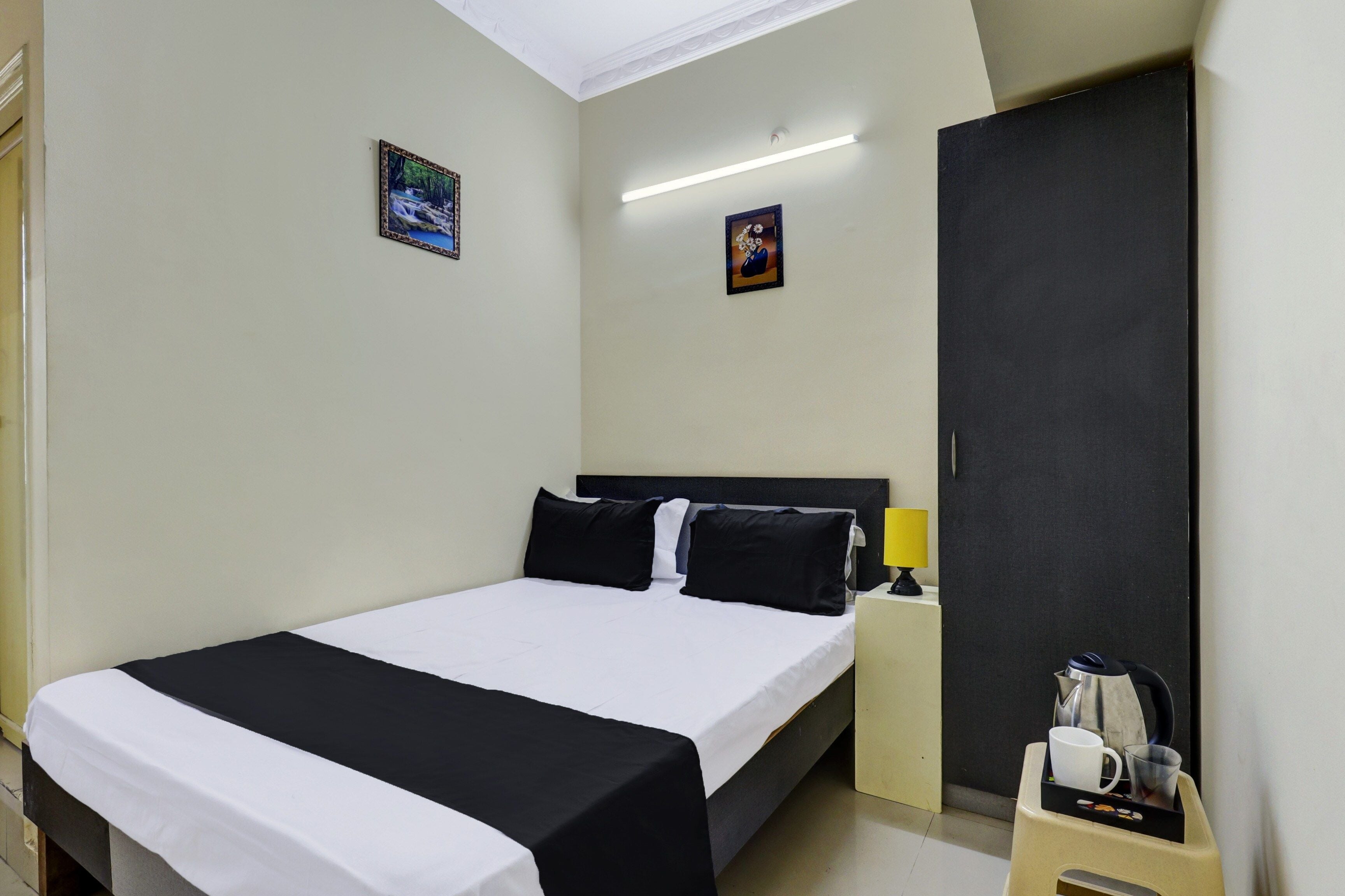 A hotel room with a bed, a nightstand, a lamp, and a coffee maker.