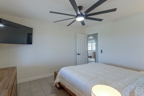 A bedroom with a bed, a ceiling fan, a mounted TV, and a door leading to another room. - Golf, Boat, Swim! Home w/ Lake Havasu & Mtn Views (Lake Havasu City)