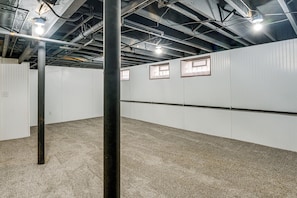A room with white walls, a black ceiling beam, and a carpeted floor. - Historic Detroit Charm Near Area Hospitals (Detroit)