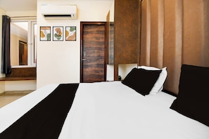 A hotel room with a bed, a door, an air conditioning unit, and a window with curtains. - OYO 835663 Hotel Drishti Grand (Lucknow)