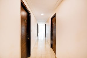 Un pasillo con puertas de madera, numeradas 102 y 107, que conduce a habitaciones.