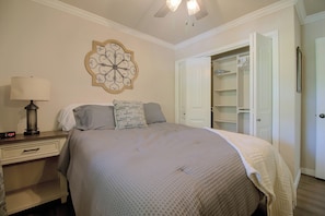 A bedroom with a bed, bedside table, lamp, and a decorative wall piece. - Eucha Home: Grand Lake Views, Boat Ramp Access (Eucha)