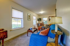 A living room with a large window, a television, a lamp, and a bookshelf. - Saint Albans Home: Walk to Main Street! (Saint Albans City)