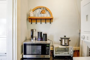 A kitchen with a microwave, toaster, and a slow cooker on the counter. - Walk to Pickleball, Parks, Pubs! Cozy Dtwn Apt (Bakersfield)