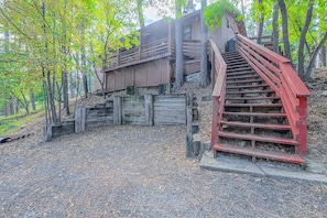 A wooden staircase leading up to a building surrounded by trees. - Walk to Midtown! Family Getaway w/ Wraparound Deck (Ruidoso)