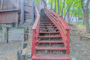 Eine rote Holztreppe führt zu einem Gebäude mit einem Gitterzaun.