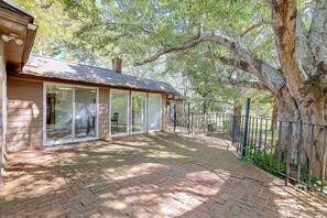 A covered outdoor area with a brick pathway leading to a building with large windows and a metal fence. - Lake Hartwell Home w/ Quiet Patio & Lake Access (Townville)