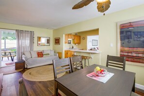 A cozy living area with a sofa, a dining table, and a kitchen in the background. - Pet-Friendly Central Home w/ Fenced Yard! (San Diego)