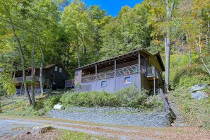 A rustic cabin with a balcony, surrounded by dense forest. - Rustic Cabin-Stunning View-Cov Porch<br>Delaware Gem! (Damascus)