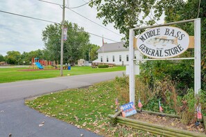 A sign for Middle Bass General Store with a playground in the background.