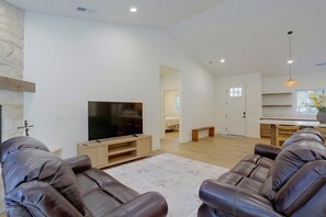 A modern living room with a flat-screen TV, leather sofas, and a wooden entertainment unit. - Bring Your Boat! Home w/ Patio Near Lake Almanor (Chester)