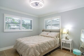 A bedroom with a bed, a bedside table with a lamp, and two windows with blinds. - Canal-Front Retreat w/ Dock! 5 Mi to Dtwn St Pete (St. Petersburg)