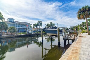 A marina with boats docked, a house with a balcony, and palm trees. - Canal-Front Retreat w/ Dock! 5 Mi to Dtwn St Pete (St. Petersburg)
