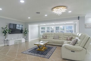 A modern living room with a sofa, coffee table, and TV. - Canal-Front Retreat w/ Dock! 5 Mi to Dtwn St Pete (St. Petersburg)