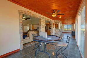 A spacious indoor area with a stone fireplace, a ceiling fan, and a dining table with chairs. - Near Hiking! Mtn-View Poolside Retreat in Phoenix (Phoenix)