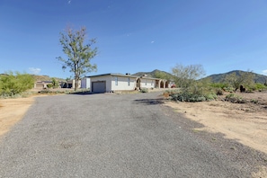 A residential property with a gravel driveway, a garage, and a house with a flat roof. - Near Hiking! Mtn-View Poolside Retreat in Phoenix (Phoenix)