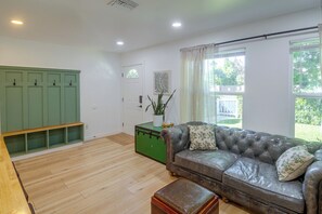 A living room with a leather sofa, a green trunk, and a wooden bench. - North Hollywood Home, Extended Stay (Los Angeles)