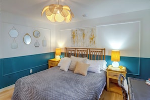 A bedroom with a large bed, two bedside tables with lamps, a wall-mounted mirror, and a ceiling light fixture. - North Hollywood Home, Extended Stay (Los Angeles)