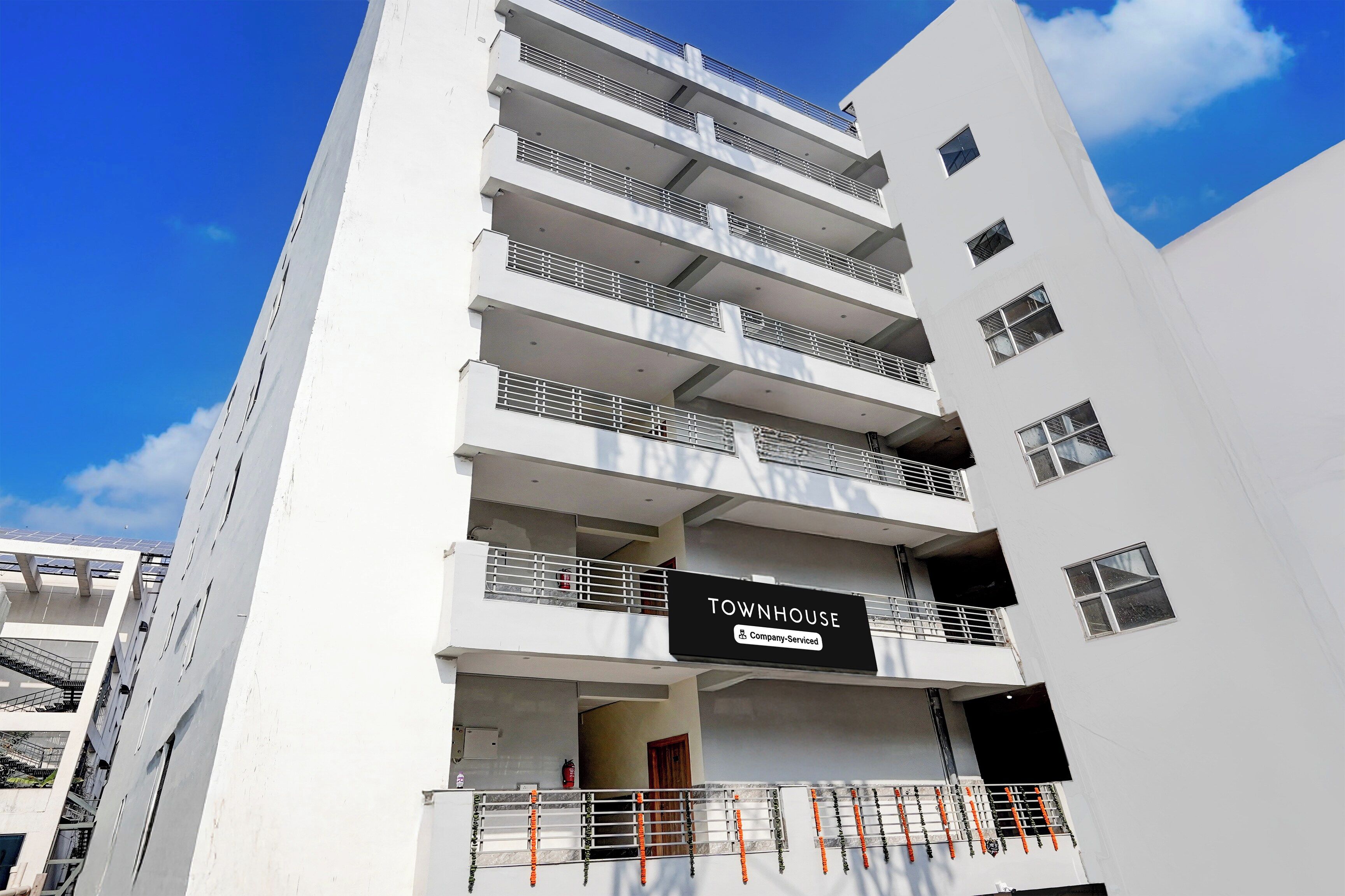 A multi-story building with a sign indicating it is a company-serviced townhouse.