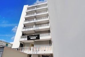 Un edificio de varios pisos con un letrero que indica que es una casa adosada con servicios de empresa.