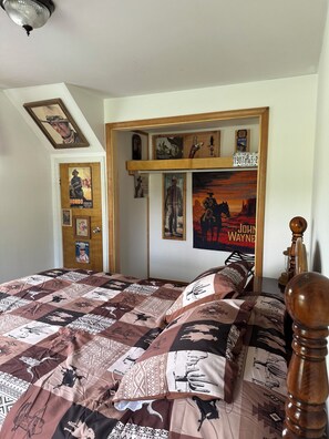 Ein Schlafzimmer mit einem Bett, Postern und einem hölzernen Kopfteil.