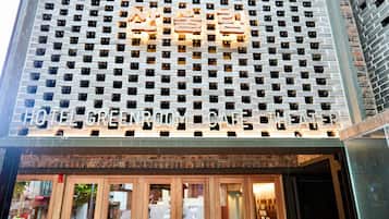 L’entrée d’un hôtel, avec une façade moderne en briques et de grandes fenêtres.