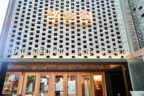 Fachada de hotel moderna con ladrillos y ventanas grandes.