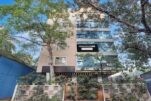Un edificio de varios pisos con un letrero que indica 'TOWNHOUSE OAK' y 'Servicio de la empresa'.