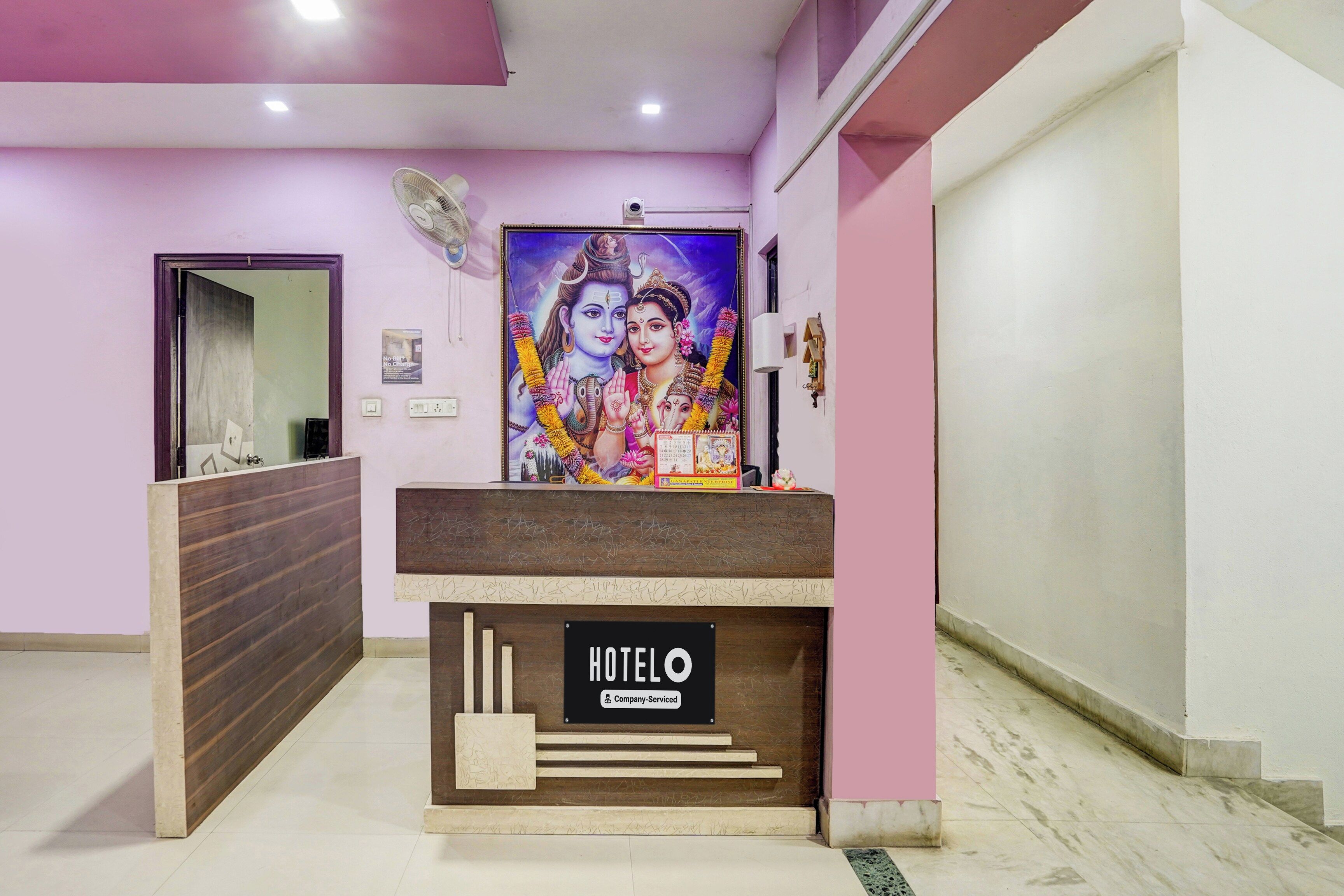 A hotel reception desk with a sign indicating it is company-serviced.