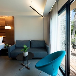 Una sala de estar moderna con un sofá, una mesa de centro redonda y un sillón azul.