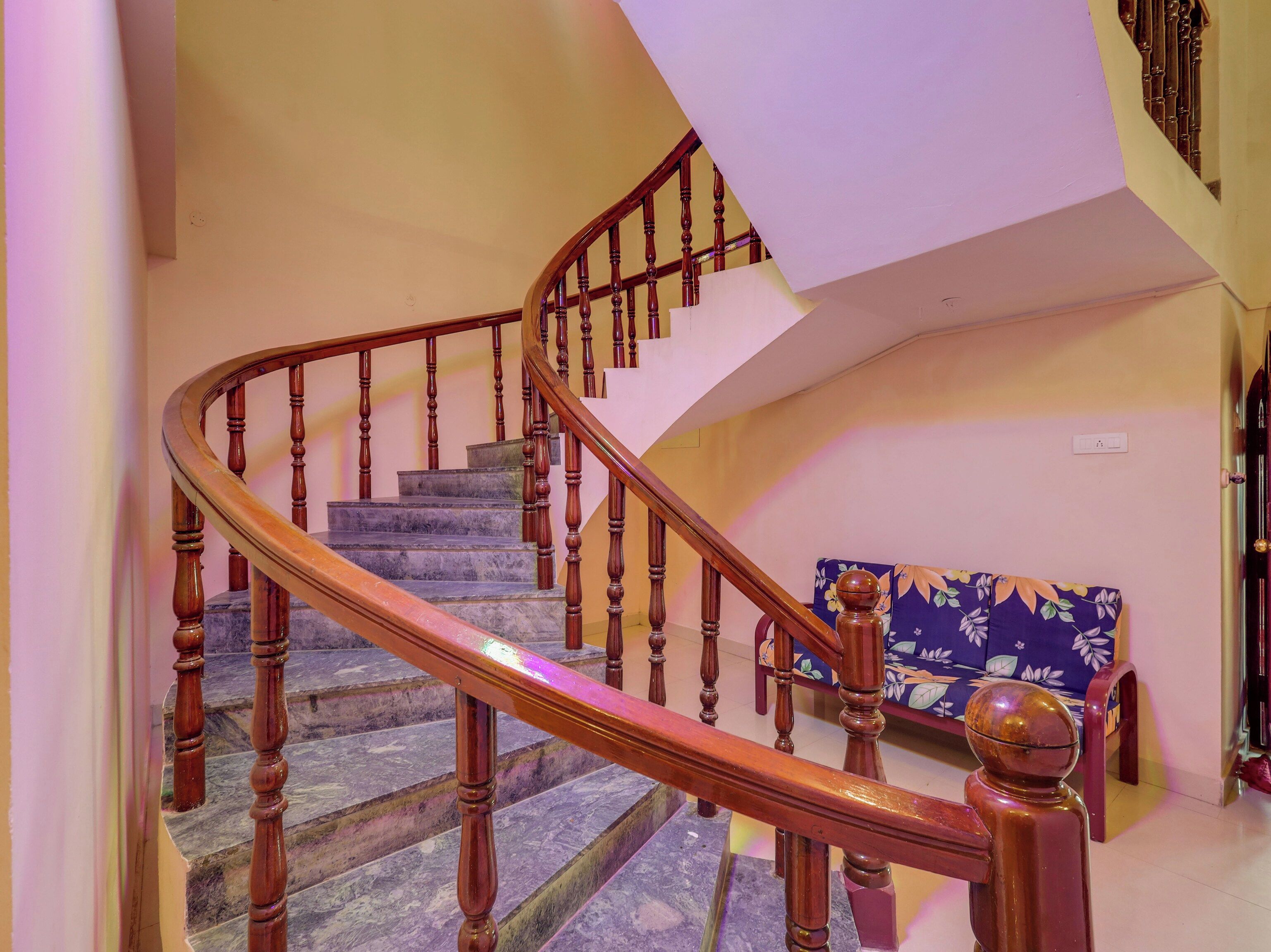 Un escalier en bois, doté d’une rampe, mène à un palier.