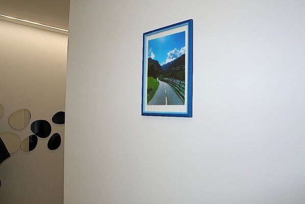 Fotografía enmarco de un camino con montañas sobre una pared blanca.