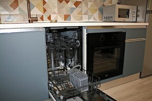 A kitchen with a dishwasher, an oven, and a microwave on the countertop. - New Listing (Roma)