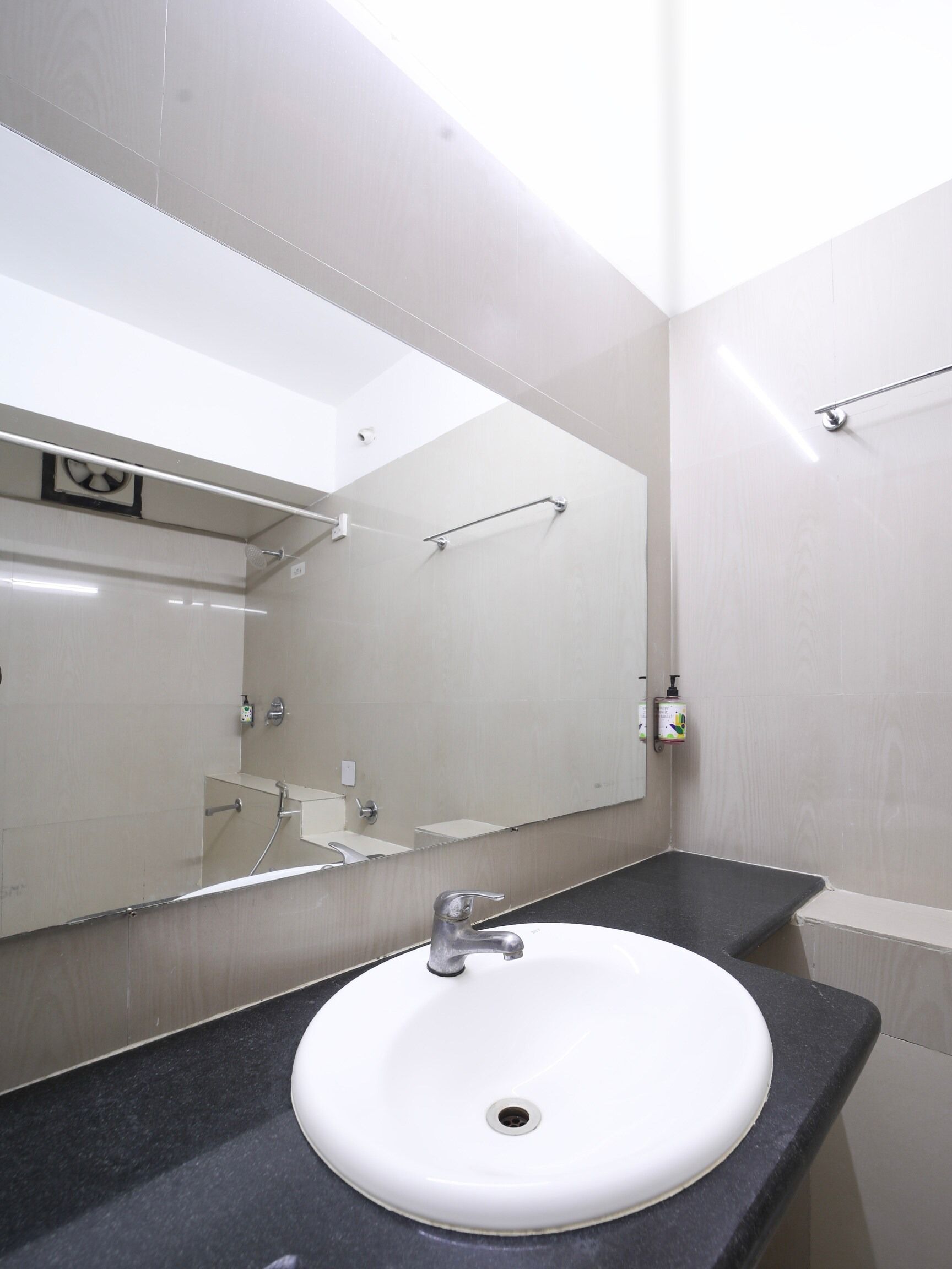 Une salle de bain avec un lavabo blanc, un miroir et un porte-serviettes.