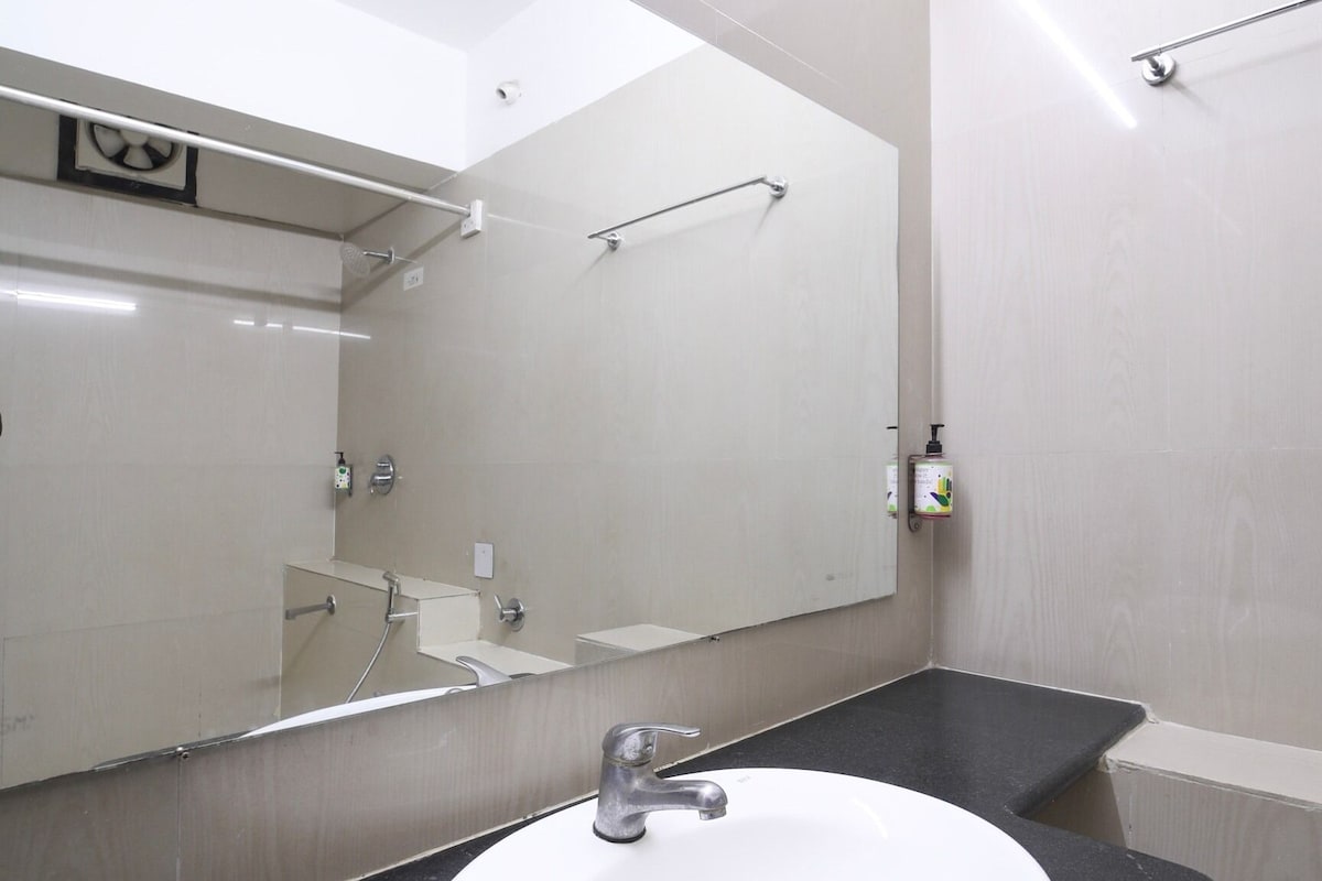A bathroom with a white sink, a mirror, and a towel rack.