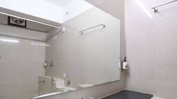 Une salle de bain avec un lavabo blanc, un miroir et un porte-serviettes.