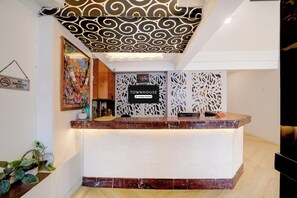 A reception desk with a 'No Smoking Zone' sign, a digital clock, and a 'Townhouse' sign.