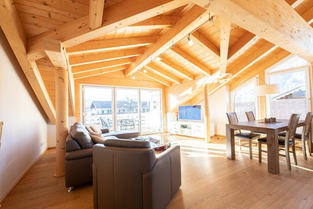 A spacious loft with a high ceiling, a dining area, and a comfortable seating area.