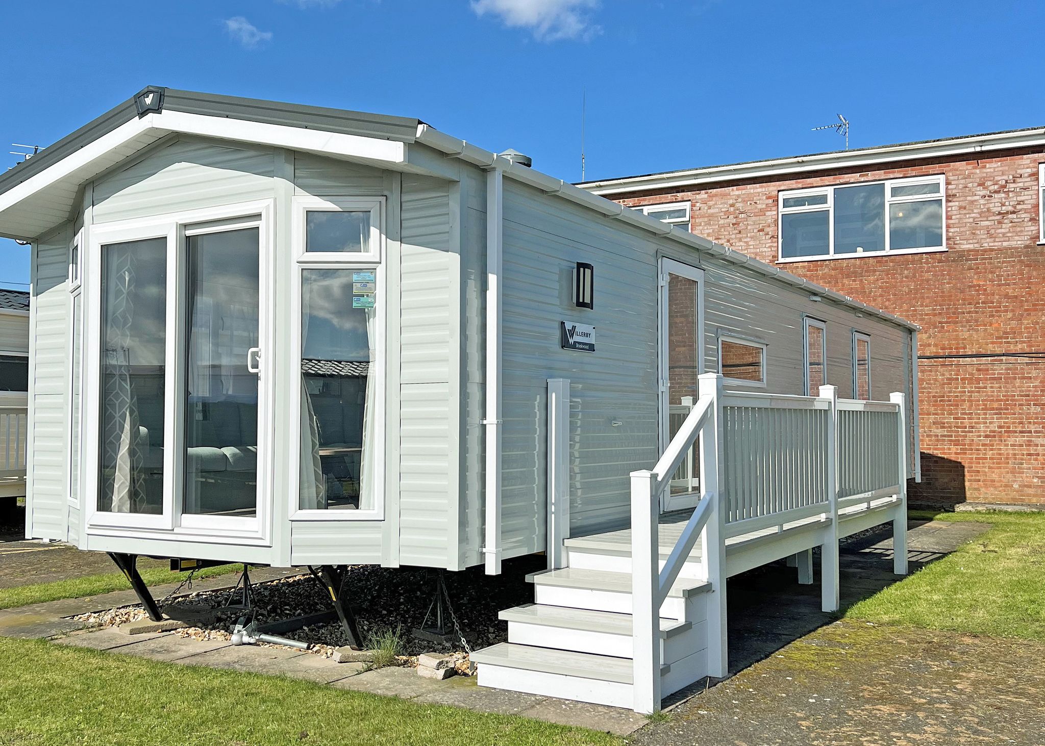 A mobile home with a front porch and a staircase leading to the entrance.