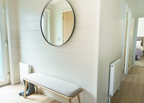 A room with a bench, a radiator, and a mirror on the wall. - Autograph Retreat Hot Tub 3 bed Luxury Lodge slps6 (Landford, Nr Salisbury)